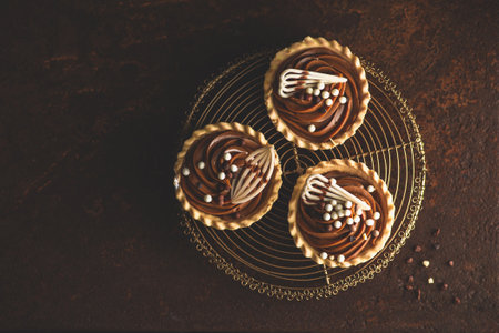 Chocolate cupcakes with whipped cream on dark background, top viewの写真素材