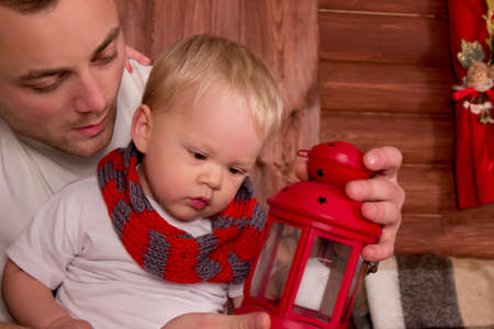 Father playing with her child in christmas decoration in front of christmas-treeの写真素材