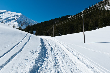 Photography in the mountains in winter. Beautiful blue sky and mountains in the snow. The road, Which roam the people.の写真素材