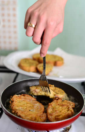 Hand twiddles the egged breads in the frypanの写真素材