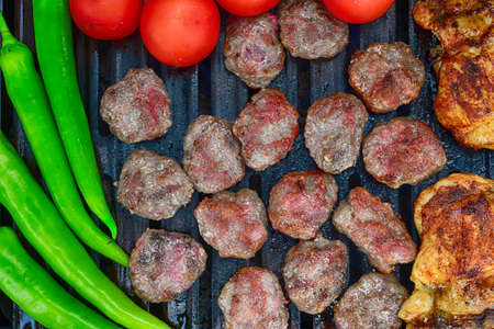 Chicken and meatball roasting on barbecueの写真素材