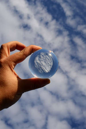 Reflection of clouds beyond glass sphereの写真素材