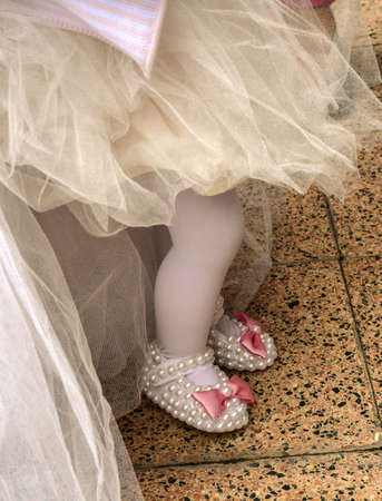 Babygirl on her first birthday party with tulle skirt and slippersの写真素材