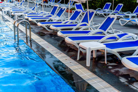 Poolside with blue chezlongs and pool close up viewの写真素材