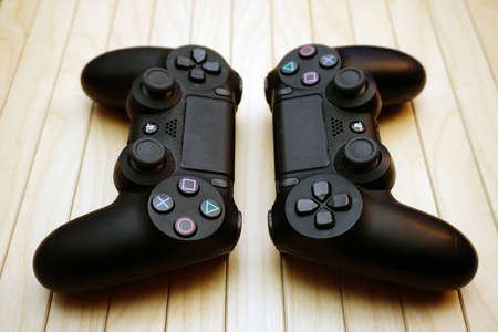 22.03.2019 Eskisehir, Turkey. Two ps4 gamepads on wooden background close up view