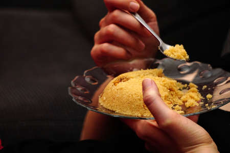 Eating Semolina helva dessert eating close up view in the glass dishの写真素材