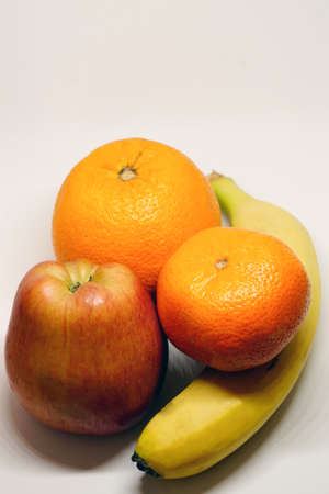Orange mandarin banana and apple on white isolated backgroundの写真素材