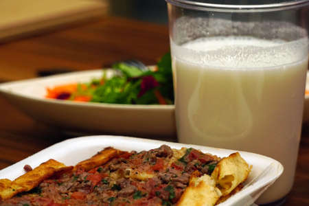 Meat cubed pitta bread drinkable yoghurt and salad on wooden background close up viewの写真素材