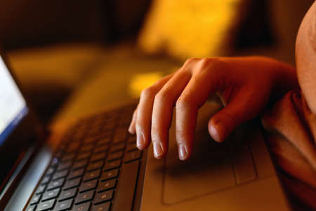Woman hand on laptop keyboard working at home home office conceptの写真素材