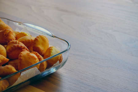 Leavened dough pastry on glass dish on wooden background with copyspace Turkish breakfast concept
