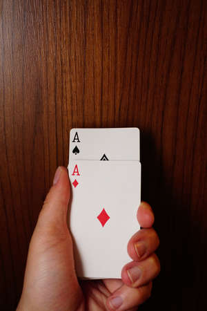 Poker cards with assorted combinations in man hand close up and isolated backgroundの写真素材
