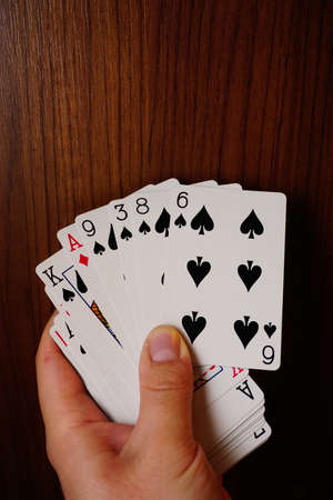 Poker cards with assorted combinations in man hand close up and isolated backgroundの写真素材