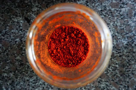 Powdered red pepper in the jar close up viewの写真素材