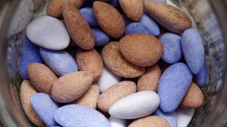 Sweet covered almonds with blue and brown color in the jar close up viewの写真素材