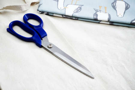 White fabric and blue scissor on isolated background close up viewの写真素材