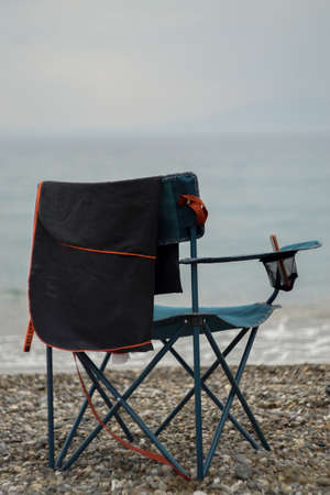 Collapsible beach chairs on pebble stone beachの写真素材