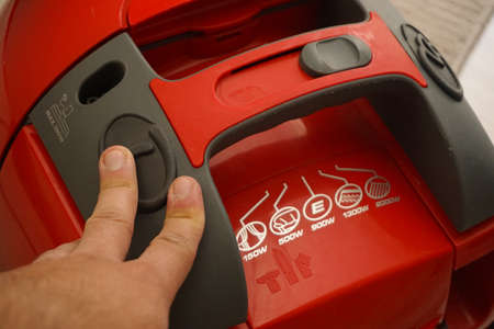 Man pushing power button on vacuum cleaner close up viewの写真素材
