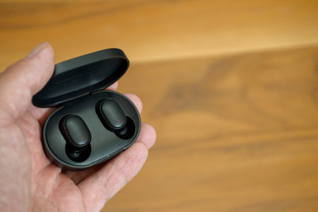 Wireless earphones with charge case in man hand close up viewの写真素材