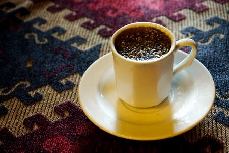 Traditional Menengic coffee on porcelain cup on ethnic table clothの写真素材