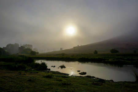 Camping in the nature waking up into a misty sunriseの写真素材