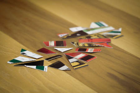 Broken credit cards on wooden background close up viewの写真素材