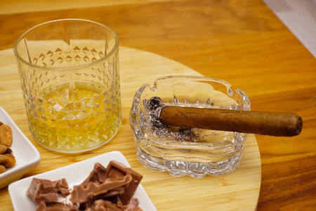 Cigar whiskey chocolate and nuts on wooden table close up viewの写真素材