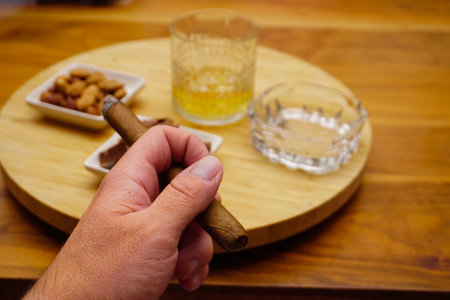 Cigar whiskey chocolate and nuts on wooden table close up viewの写真素材