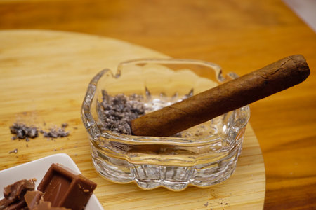 Cigar whiskey chocolate and nuts on wooden table close up view