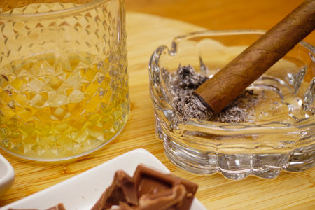 Cigar whiskey chocolate and nuts on wooden table close up viewの写真素材