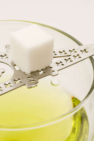 Sugar cube on spatula above wine glassの写真素材
