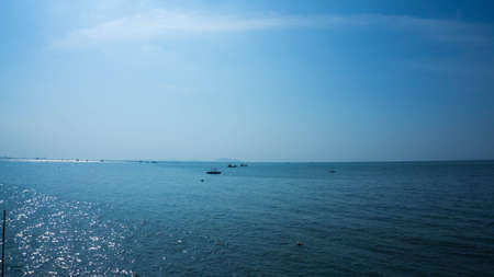Ocean under clear blue sky with many boat