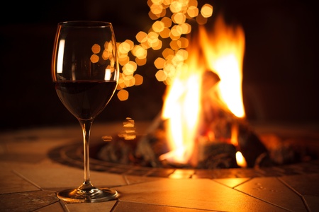 Glass of Red Wine by a Warm Fireの写真素材