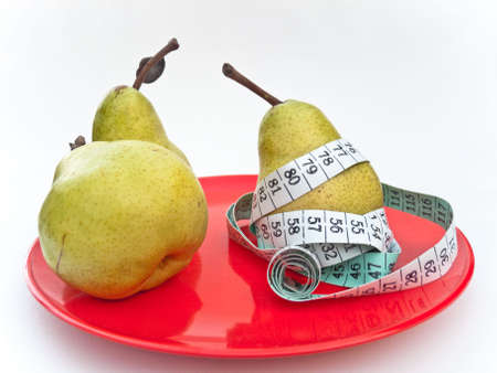 Pears on red plate with measuring tape. Health concept.の写真素材