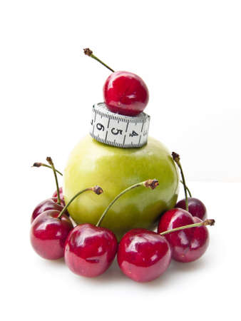 A granny smith apple with cherry with measuring tape. Health concept.の写真素材