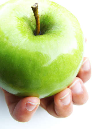 A hand offering a granny smith apple. の写真素材