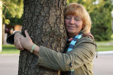 Tree-hugging senior womanの写真素材