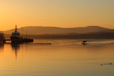 Float plane landing in harbor at sunset in Patricia Bay on Vancouver Islandの写真素材
