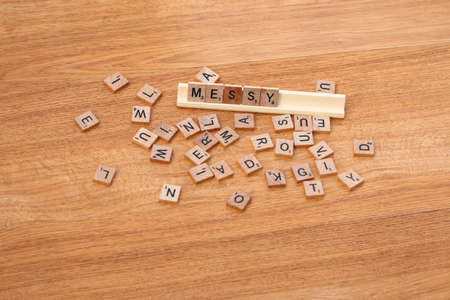 A scrabble word, MESSY, written among messy, unorganized scrabble pieces.のeditorial素材