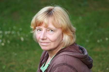 Smiling mature woman green backgroundの写真素材