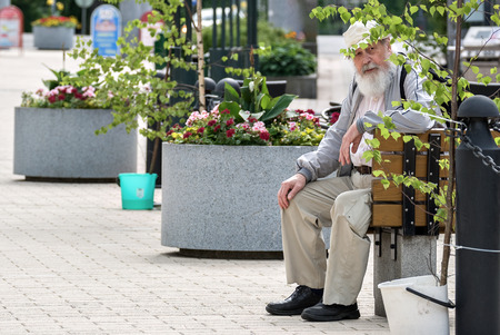 IMATRA, FINLAND, June 24: The old man has a rest, sitting on a bench on a hot summer day in the streets of the Finnish town of Imatra, 24 June 2016.のeditorial素材