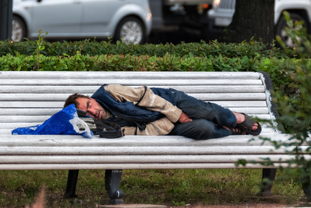 SAINT PETERSBURG, RUSSIA, may 15: A homeless man sleeping on a bench in the town square, in the morning may 15, 2016.のeditorial素材