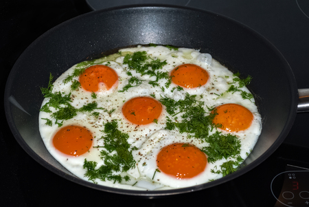 Delicious and nutritious fried eggs with dill, fried in a frying pan.の写真素材