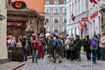 Riga, Latvia, may 02: Tourists walk along one of the streets near the medieval restaurant Rozengrals in the old part of Riga, may 02, 2019.のeditorial素材
