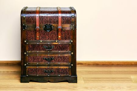 Commode, made in the form of an old chest of brown against a pink wall.の写真素材