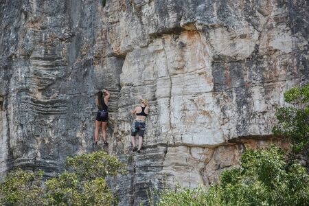 Rovinj, Croatia, August 22: Tourist climbers conduct training on steep stone slopes in Zlatni Rt forest Park, August 22, 2019.のeditorial素材
