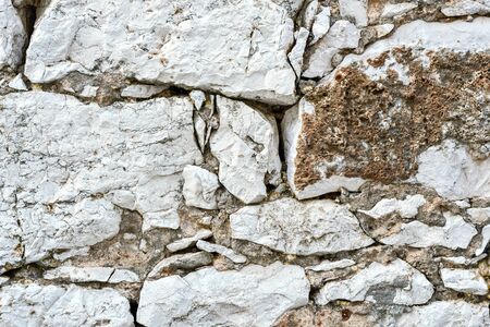 Fragment of a stone wall of white sandstone covered with red lichen. For use as an abstract background.の写真素材