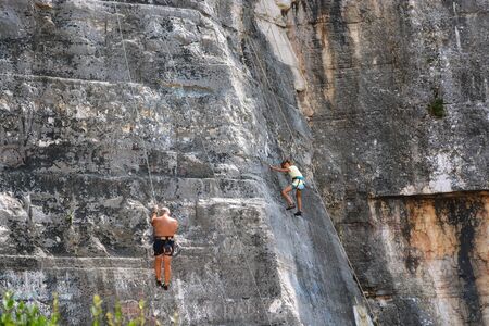 Rovinj, Croatia, August 22: A family of climbing tourists hold training sessions on steep stone slopes in the Zlatni Rt forest Park, August 22, 2019.のeditorial素材
