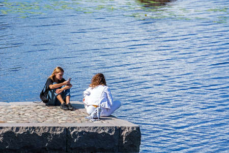 Vyborg, Russia, July 9: Two young men relax on a pier in Mon Repos park in the city of Vyborg, July 9, 2020.のeditorial素材