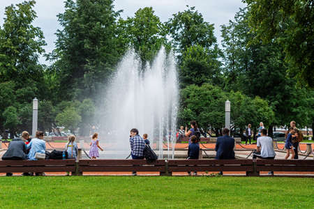 Saint Petersburg, Russia, August 3: Tourists and townspeople rest near the fountain in the city square on a warm summer day in St. Petersburg, August 3, 2020.のeditorial素材
