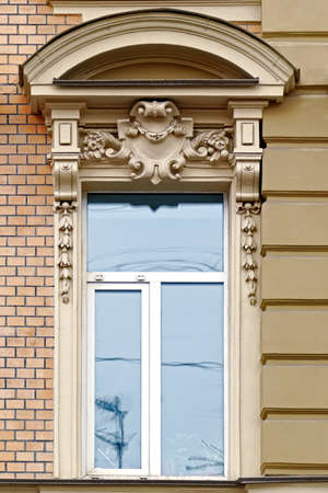 Rectangular window with arched visor stucco on the background of the beige wall. From the windows of St. Petersburg series.の写真素材
